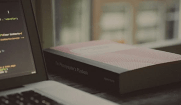 A laptop with a book next to it